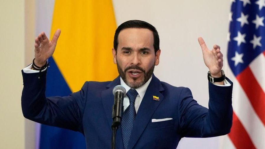 Colombian President Abelardo De La Espriella speaks in Barranquilla, Colombia, September 8, 2026. He is wearing a navy suit and behind him a US and a Colombian flag can be seen. He is holding his arms up in the air as he gestures. Fernando Vergara/Pool via REUTERS