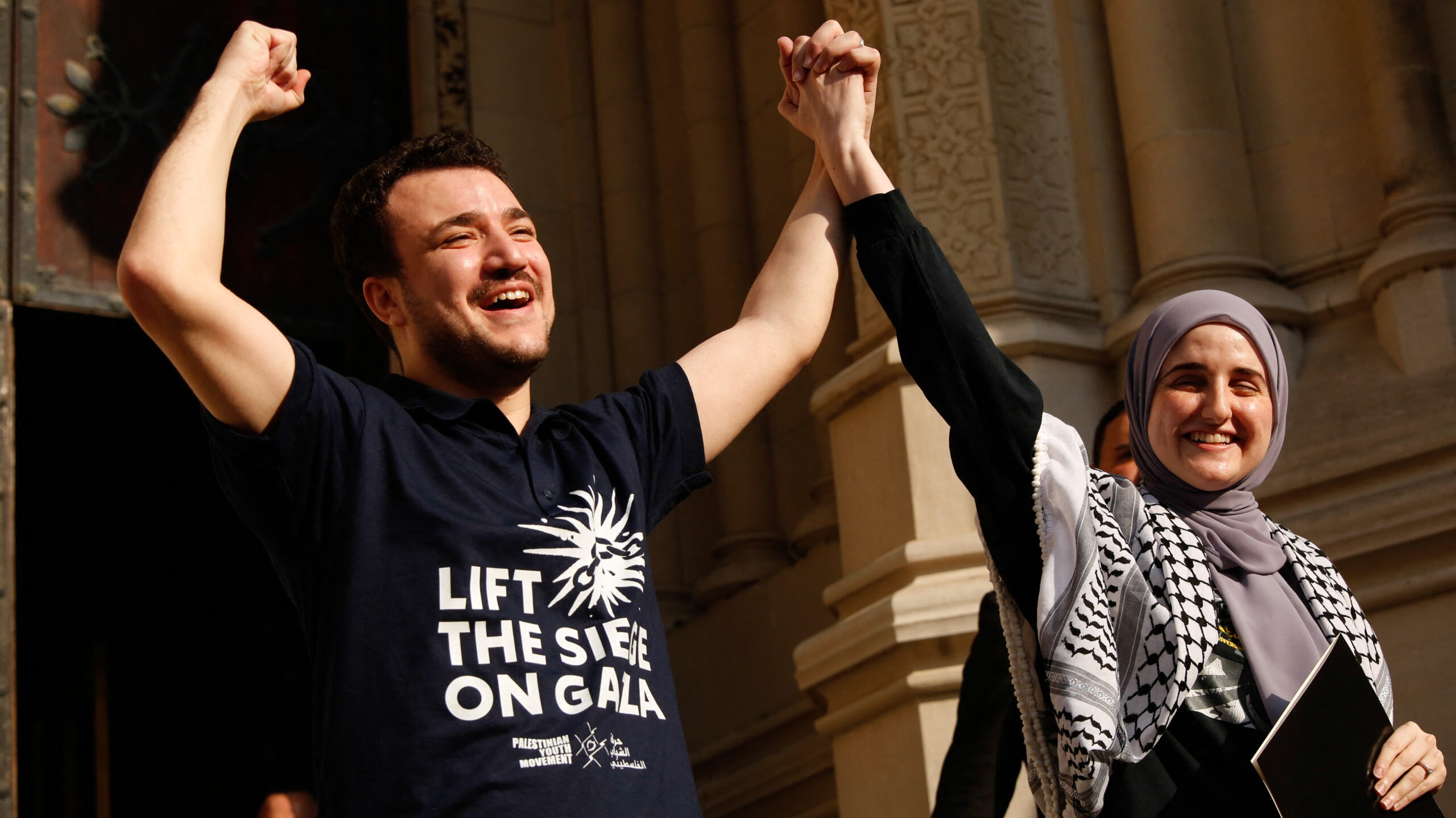 Mahmoud Khalil, accompanied by his wife Noor Abdalla, raises his hands as he arrives for a press conference in New York City on June 22, 2025, two days after his release from U.S. custody.