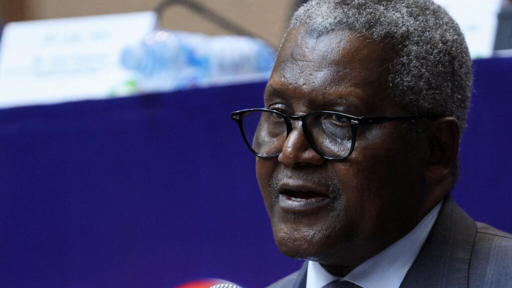 A close-up photo of Aliko Dangote. He is wearing glasses and a suit, with short, salt and pepper hair.