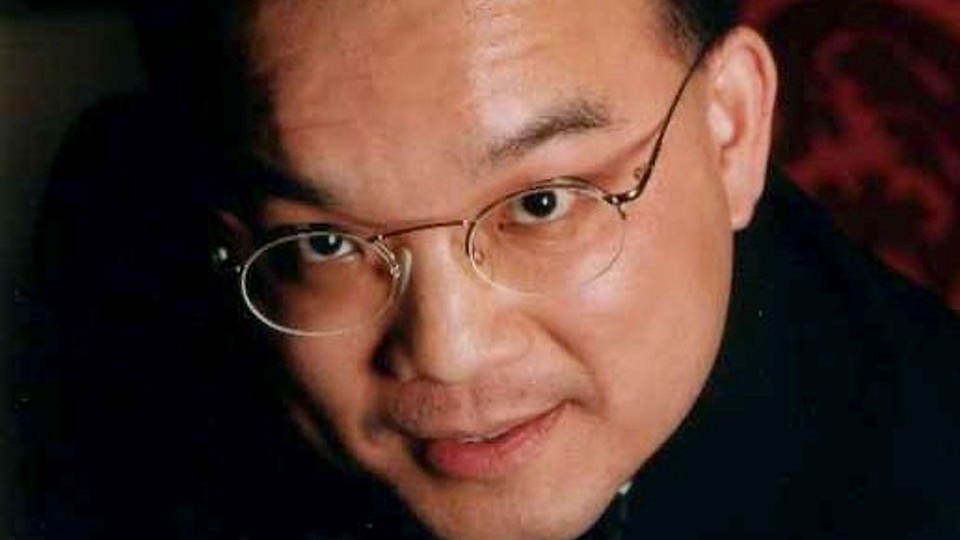 Close up image of Kenneth Law's face. He is looking at the camera and is wearing glasses.
