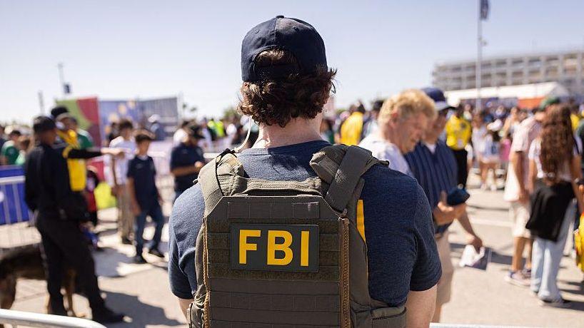 An FBI agent stands near a security point at Los Angeles Stadium (SoFi Stadium) ahead of the 2026 World Cup Group G football match between Iran and New Zealand in Inglewood, California, on June 15, 2026.
