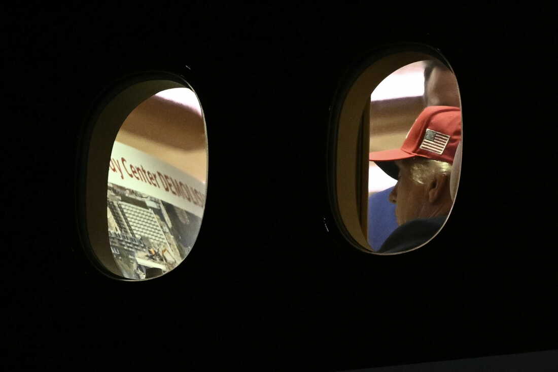 President Donald Trump is seen aboard Air Force One looking at a large Kennedy Center printout after landing in Maryland on Wednesday.