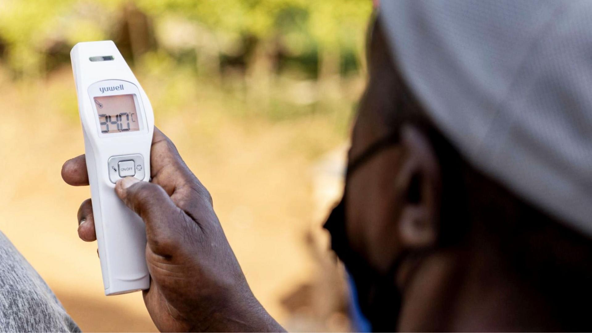 An official takes a temperature as part of Ebola preventative measures in East Africa.
