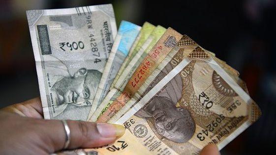 A woman holds Indian rupee notes in Siliguri, India, on October 2, 2026