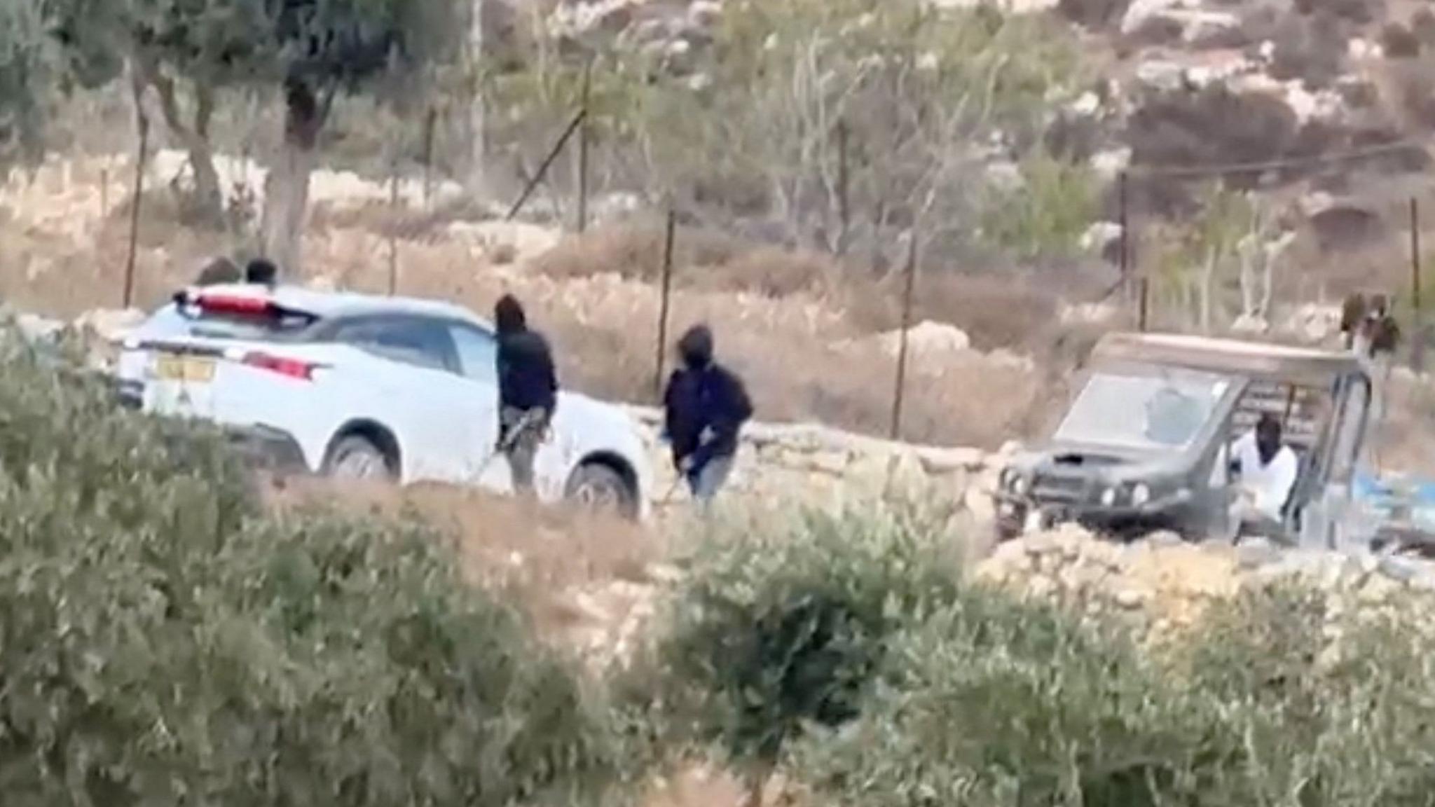 Vehicles at the site where Belgium's foreign minister says masked settlers in the Israeli-occupied West Bank attacked Palestinians, Catholic representatives and Western diplomats and officials.