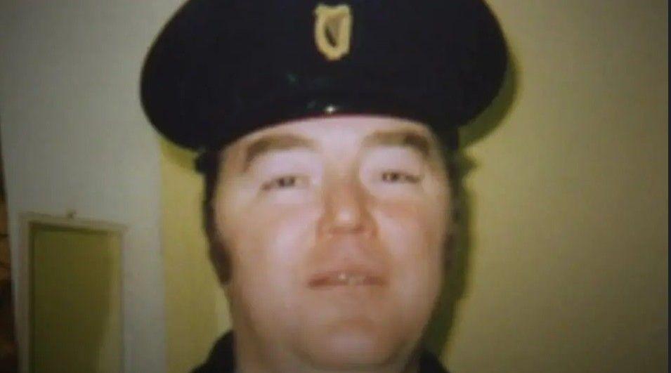 An old picture of a man with a prison officer helmet on, looking into the camera