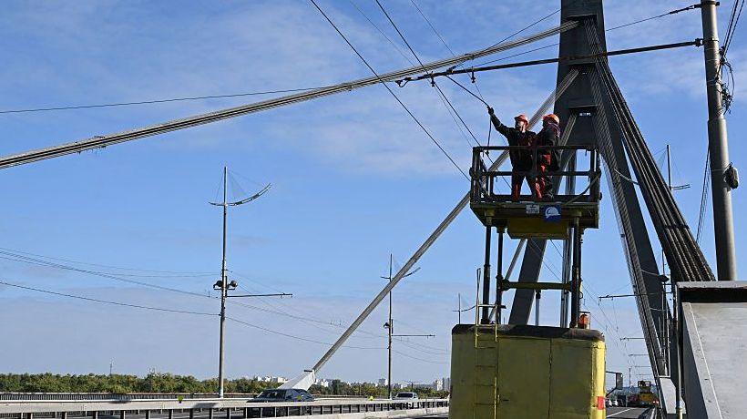 Technicians repair overhead trolleybus power lines that were damaged following an attack on the Pivnichnyi (Northern) Bridge in Kyiv, Ukraine on Saturday.