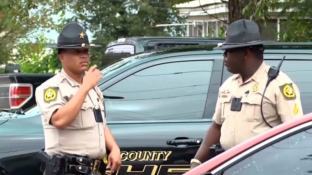 A pair of law enforcement officials pictured at the scene of a mass shooting in Vienna, Georgia
